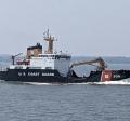 The USCG cutter Aspen on the waters of Kachemak Bay with cloudy, gray skies in the background