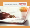Close up photo of a hand holding a credit card just above the keyboard of a laptop computer