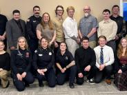 A group of 21 men and women, the back row standing, the front row kneeling