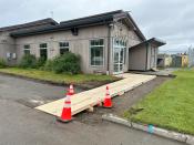 Temporary wooden ramp leading to the cargo door at Homer Airport terminal building with orange safety cones