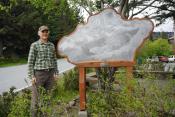 Artist Jeffrey Dean stands next to Nor'easter, a brass engraving art piece he crafted for the Fire Hall pocket park.