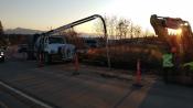 Traffic moves in one lane on Lake Street in Homer Alaska around workers fixing a broken water main pipe.