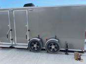 The front of the mobile restroom trailer showing two trailer wheels and two restroom doors.