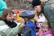 Elaine Grabowski fitting youth with bike helmet