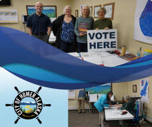 Four people standing behind a white folding table that has a VOTE HERE sign.