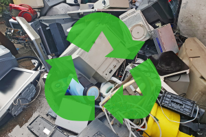 Pile of old electronics on damp concrete ground with the three green arrow recycling logo superimposed.