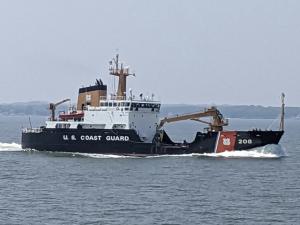 The USCG cutter Aspen on the waters of Kachemak Bay with cloudy, gray skies in the background