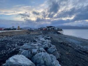 Looking south, down a line of rocks placed on the west side of Homer Spit Road above the Kachemak Bay shoreline.
