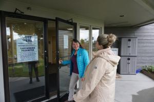 Two women smiling and laughing walking into Homer City Hall