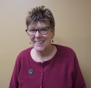 Portrait of woman in red sweater and smiling.