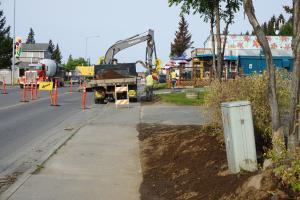 Public Works Department personnel remove sod built up over time at the sidewalk in front of Cosmic Kitchen.