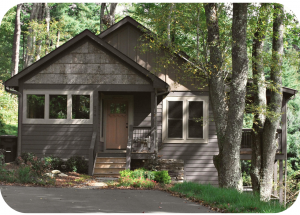 A wood-sided house in a forest setting