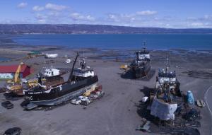 Three marine vessels hauled out and being repaired on tidelands in City of Homer Port & Harbor.