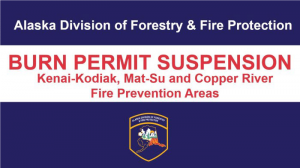 Blue and White sign with red words saying BURN PERMIT SUSPENSION