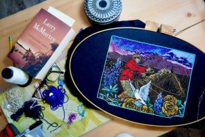A view of Kate Boyan's art studio table, featuring beadwork and books. 