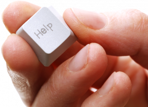 hand holding a computer keyboard key that says Help