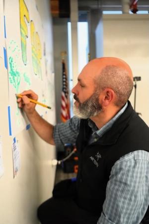 Photograph of Lee Post drawing on a wall