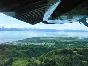 Aerial photo looking south over Homer bluffs towards the City of Homer, airport and the Homer Spit on a blue sky, summer day.