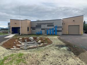 Photo of front of new Homer Police Station with rain garden in foreground.