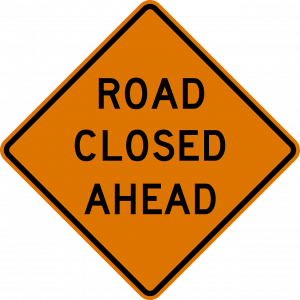 Orange diamond shaped ROAD CLOSED AHEAD sign.