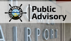 Homer Airport Terminal lettering on building with Public Advisory saying terminal is partially reopened