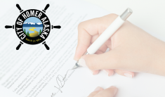 Close-up image of woman's hand signing signature on piece of paper with a white pen