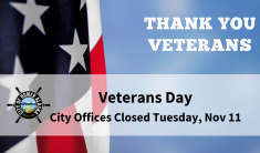 A portion of the American Flag showing three white stars on blue background and two red and white stripes with blue sky behind