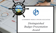 Close up of budget pages and person's hands resting on a table with the words Distinguished Budget Presentation Award overlaid.