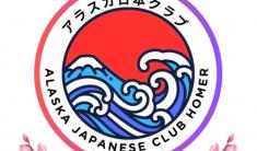 A round Alaska Japanese Club Homer logo with a spray of cherry blossoms and a stylized wave and volcano in the center