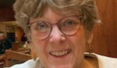 A smiling woman wearing glasses